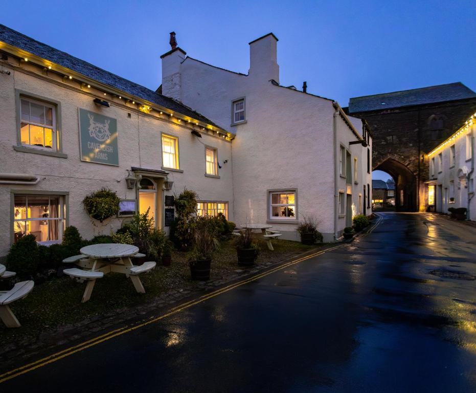 an empty street with a building and a picnic table at The Cavendish Arms in Cartmel