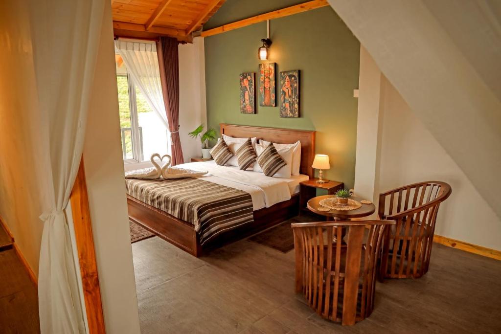 a bedroom with a bed and a table and chairs at The Mount View Single Tree Hotel in Nuwara Eliya