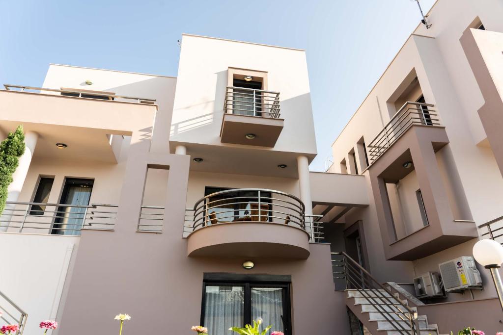 a white building with balconies and stairs at Anthemia Luxurious Villa in Iraklitsa