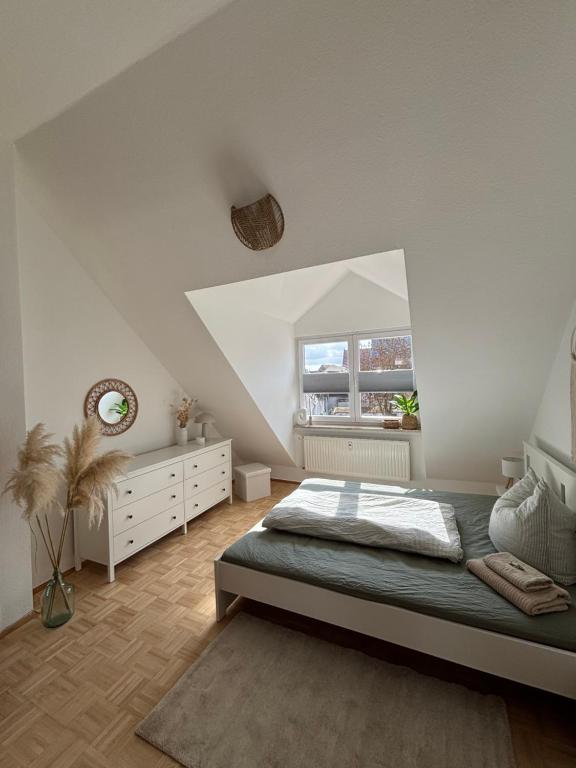 a white bedroom with a bed and a window at Altstadtgold in Rostock