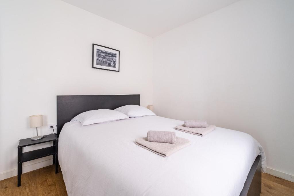 a bedroom with a white bed with two towels on it at High Five - Chambre Calme Sur Les Ramblas in Toulouse