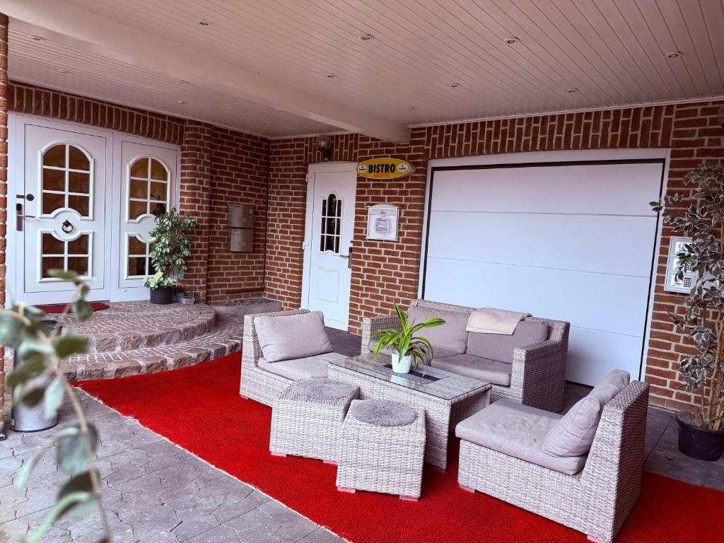 a patio with couches and chairs on a brick wall at Hotel Messeblick in Sarstedt