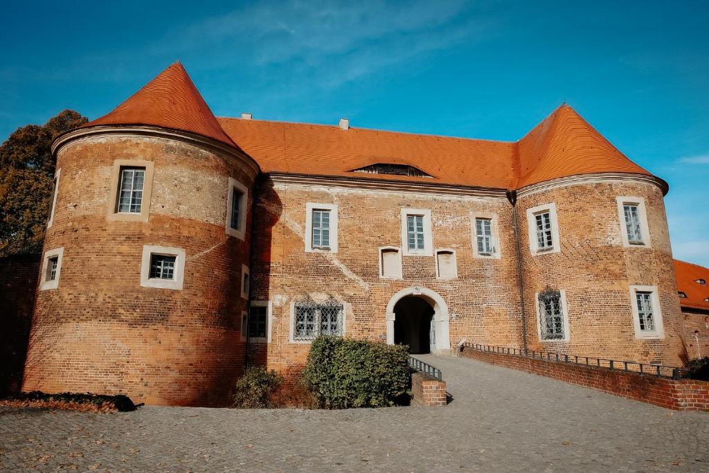 a large brick building with an orange roof at Die Burg - Kurfürstlich Flämisch in Bad Belzig