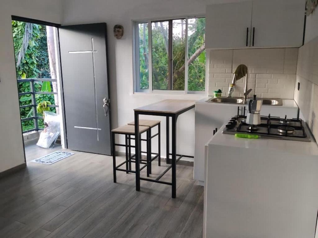 a kitchen with two bar stools and a sink and a counter at Xamanai Playa Rincón in Castellalito