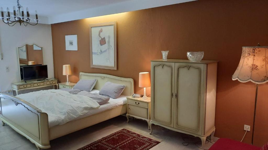 a bedroom with a bed and a dresser with two lamps at Traumhaus im Wald in Tutzing