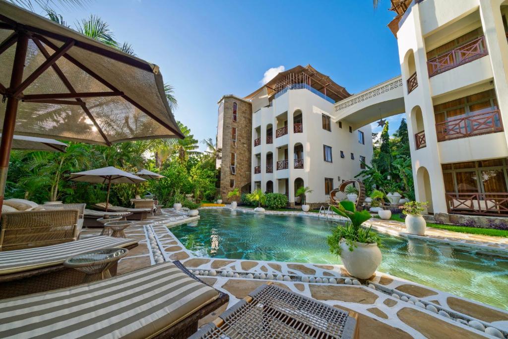 a resort with a swimming pool in front of a building at Beat's Hideaway in Galu