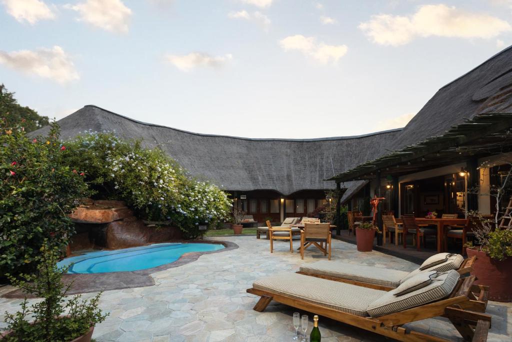 a patio with lounge chairs and a swimming pool at Elephants Footprint Lodge in Colchester