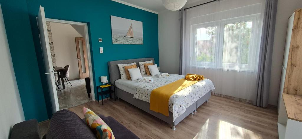 a bedroom with a bed and a blue wall at Bike & Chill Apartment in Balatonfüred