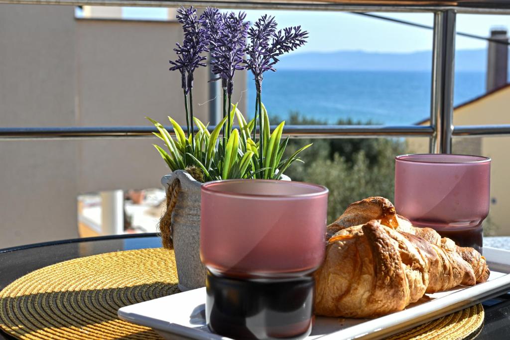 a table with a plate of bread and two glasses at apartmani sukošan in Sukošan