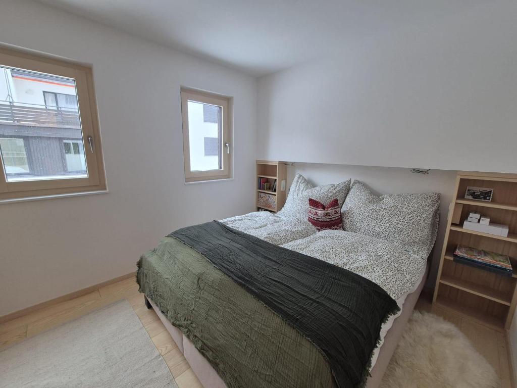 a bedroom with a bed and a window at Hemmile - Ferienwohnung in Lech in Lech am Arlberg