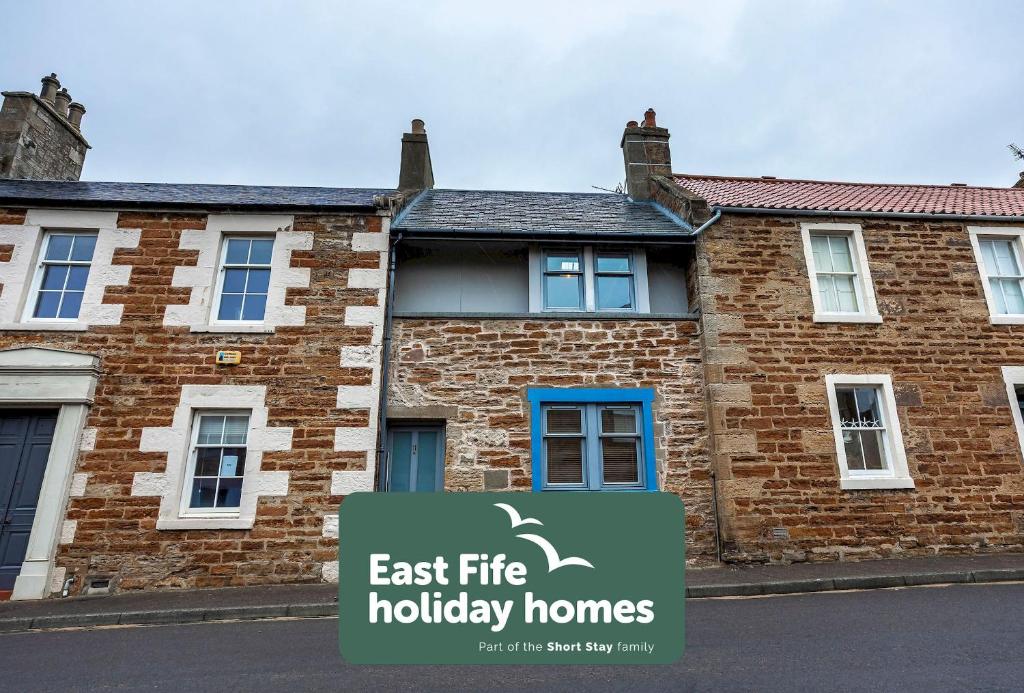 a house with a sign that reads east fire holiday homes at Creewood - Elie in Elie