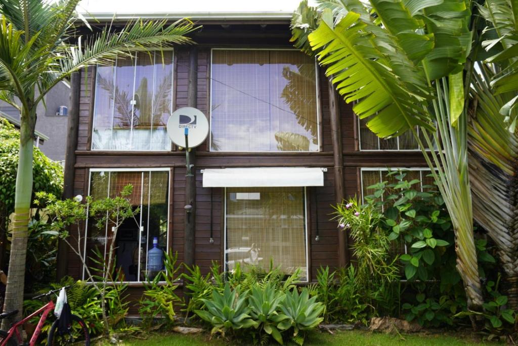 a house with a large window and plants at Casa alquiler en Bombas Bombinhas in Bombas