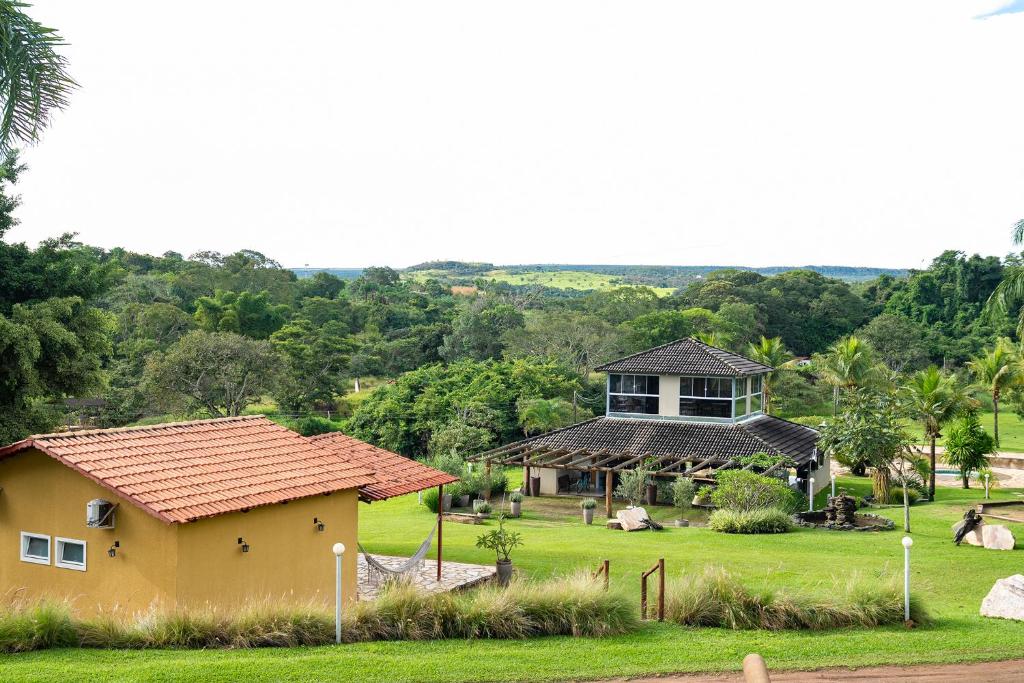 a yellow house and a building in a field at Vinícola Villa Aurum in Corumbá de Goiás