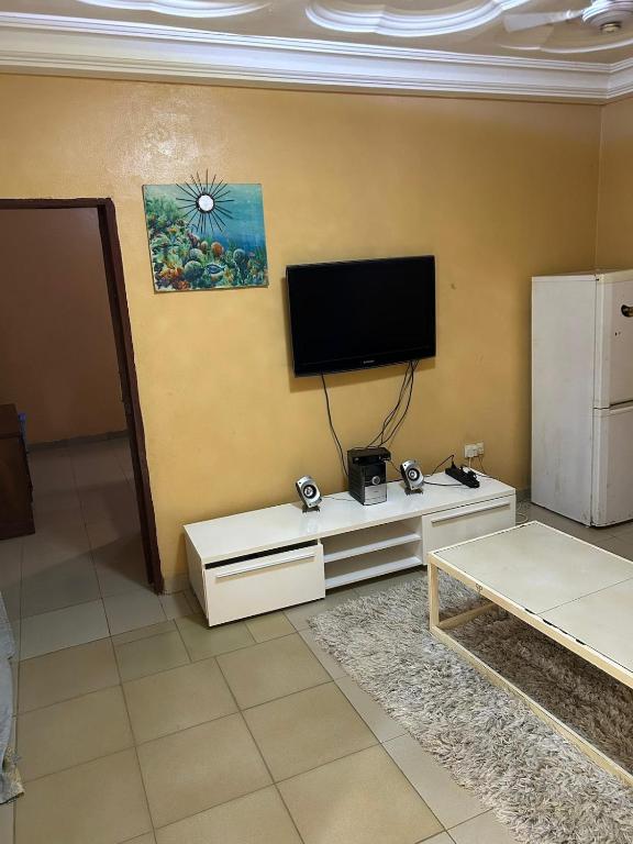 a living room with a flat screen tv on a wall at Room 11 in Kololi