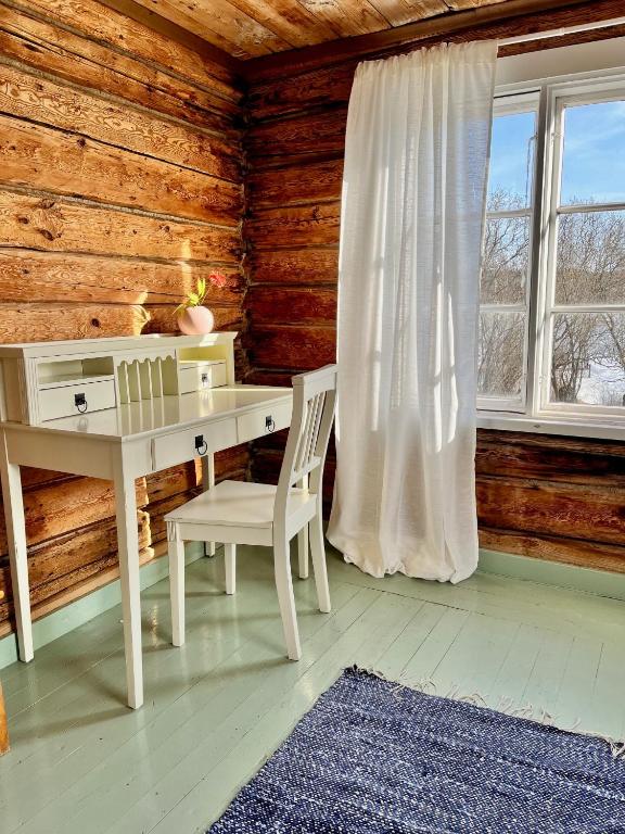 a desk and chair in a room with a window at Ahtelan torppa 1 in Salo