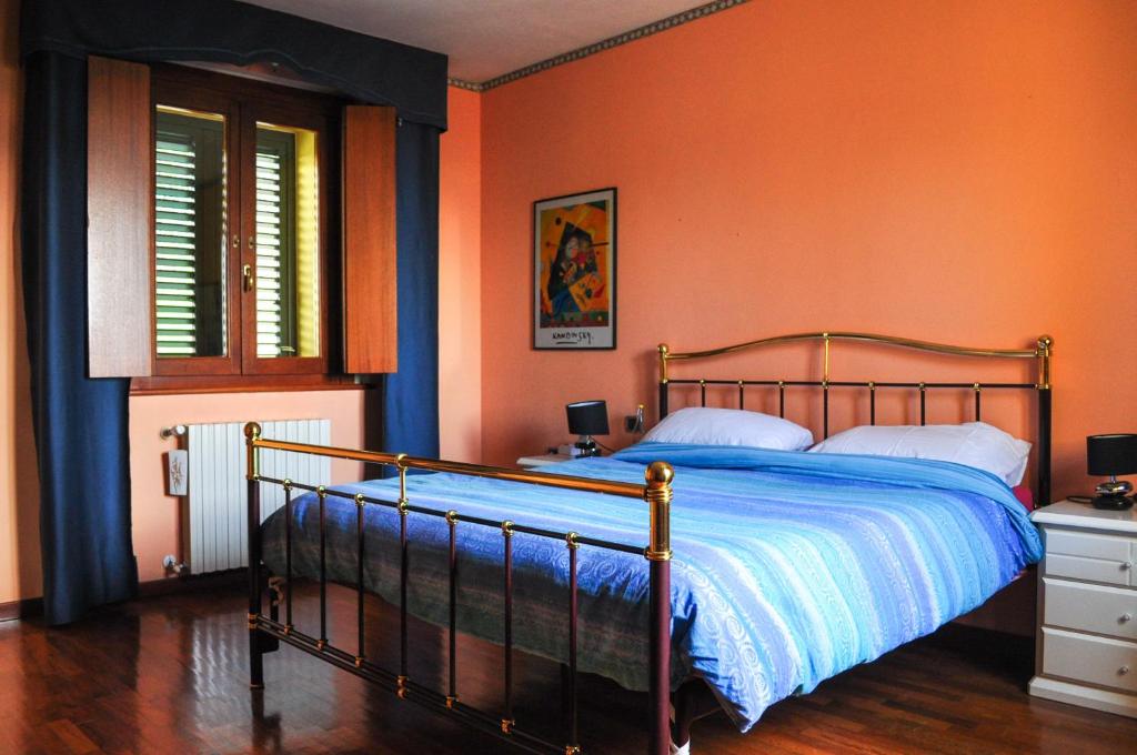a bedroom with a bed with an orange wall at Il Glicine in Làconi