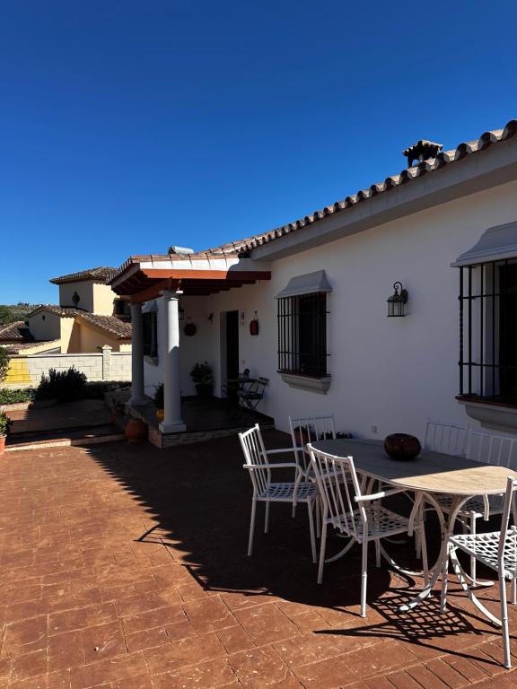 a patio with chairs and a table in front of a house at Chalet vacacional con piscina privada in Arriate