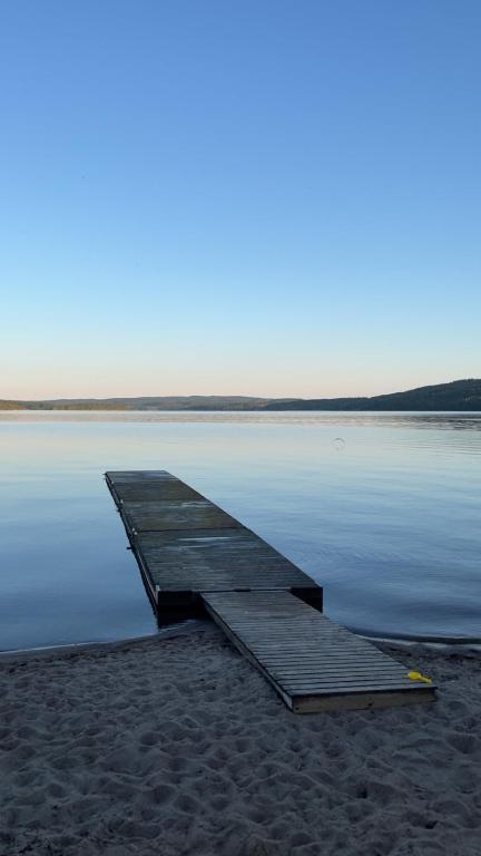 a wooden dock sitting on the shore of a body of water at Sjönära stuga i flogned in Åmotsfors