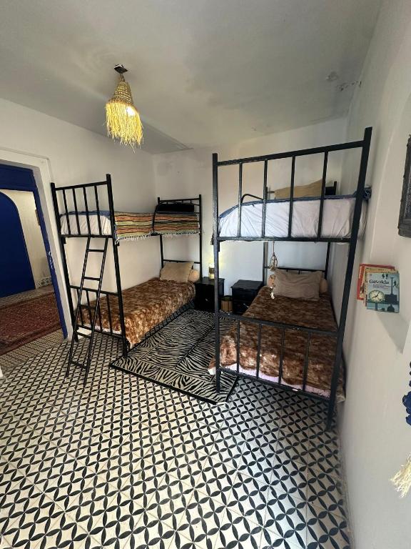 a room with two bunk beds and a chandelier at Rhythm House in Essaouira
