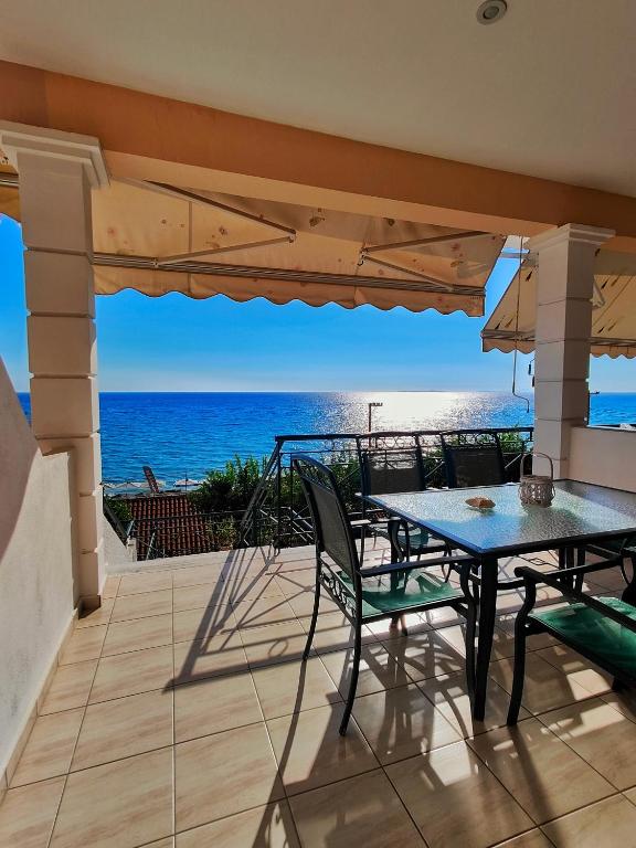 a patio with a table and chairs and the ocean at Golden Horizon Haven in Preveza