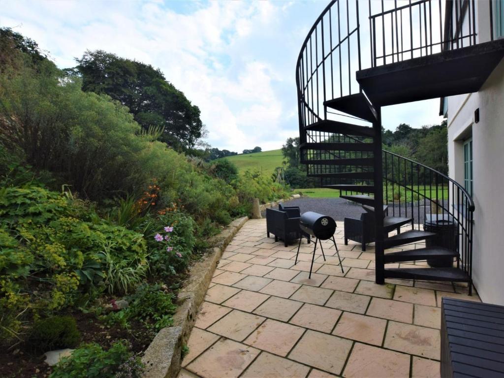 a patio with chairs and a spiral stair case at 1 Bed in Launceston oc-86674 in North Petherwin