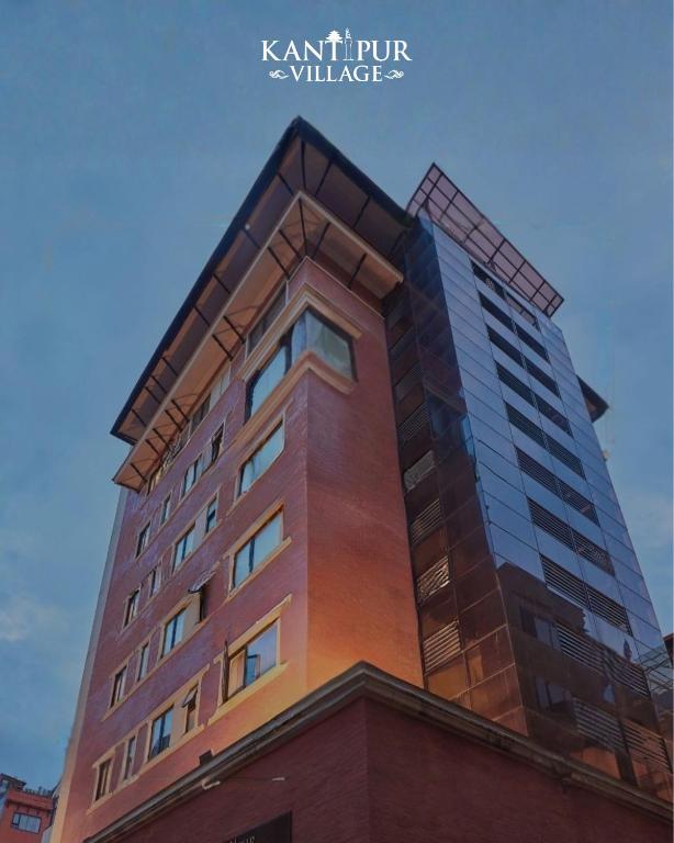 a tall brown building with a blue sky behind it at Kantipur Village in Kathmandu