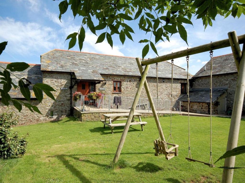 a swing in front of a stone house at 3 Bed in Bude oc-corym in Morwenstow