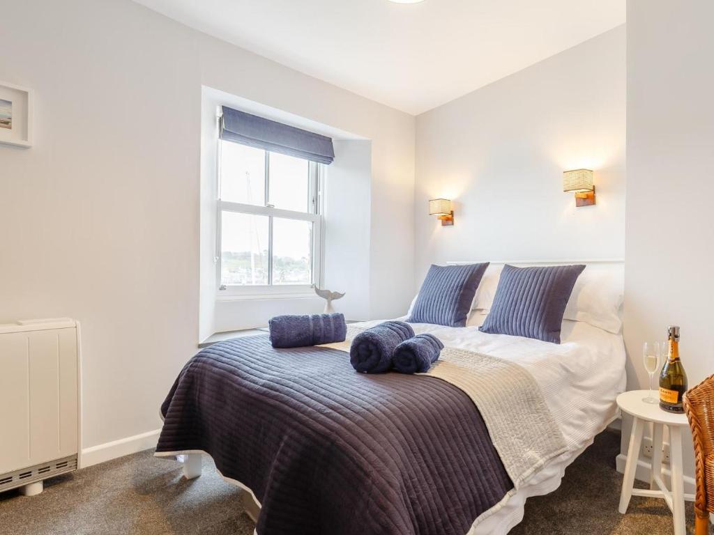 a bedroom with a bed with blue pillows on it at 2 Bed in Polruan oc-82949 in Fowey