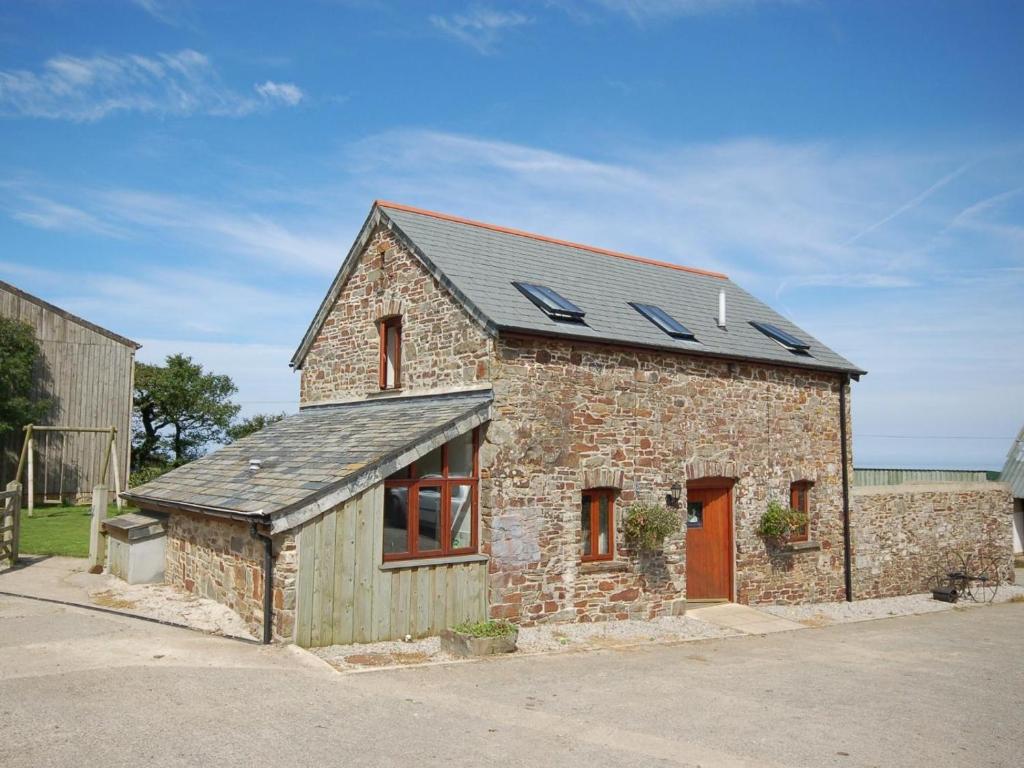 a stone building with solar panels on the roof at 2 Bed in Bude oc-coryw in Morwenstow