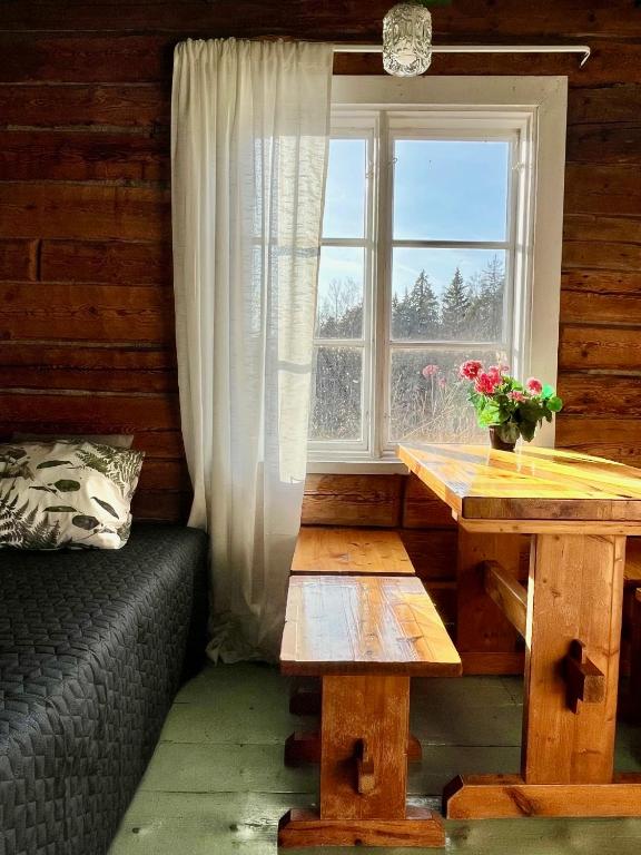 a room with a table and a window and a bench at Ahtelan torppa 2 in Salo