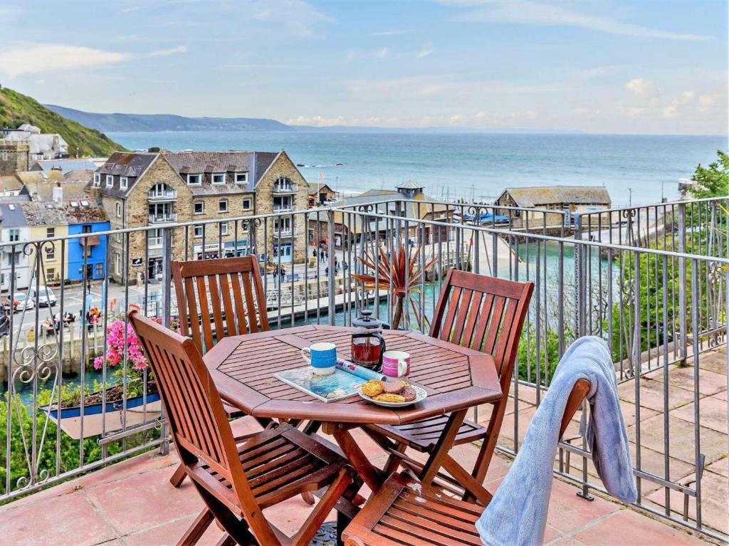 a table and chairs on a balcony with a view of the ocean at 2 Bed in Looe oc-82537 in Looe