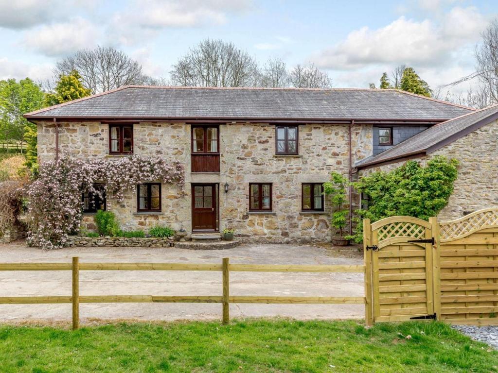 a stone house with a wooden fence in front of it at 2 Bed in St. Austell oc-82609 in St Austell