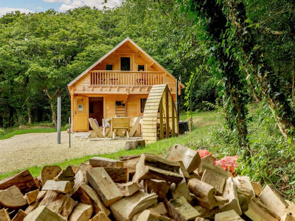 a log cabin with a pile of wood in front of it at 2 Bed in Holsworthy oc-87766 in Week Saint Mary