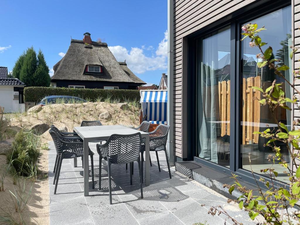 a patio with a table and chairs and a window at Hygge Hus 1 in Timmendorfer Strand