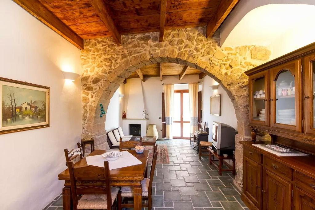 サンタンティーオコにあるAuthentic Sardinian Homeのアーチ道のあるダイニングルーム(テーブル、椅子付)
