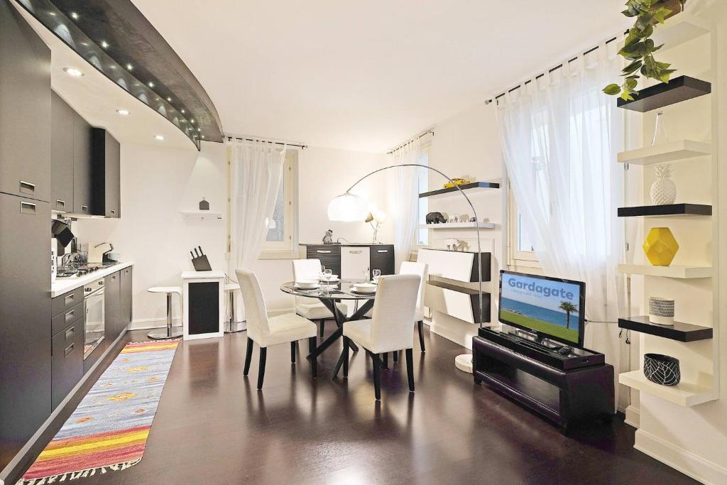 a kitchen and dining room with a table and a computer at Downtown Apartment - Gardagate in Salò