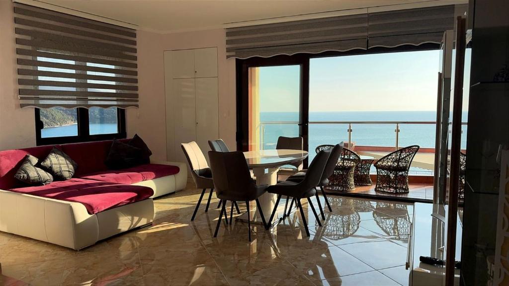 a living room with a couch and a table with chairs at Bella Costa Lux in Dobra Voda