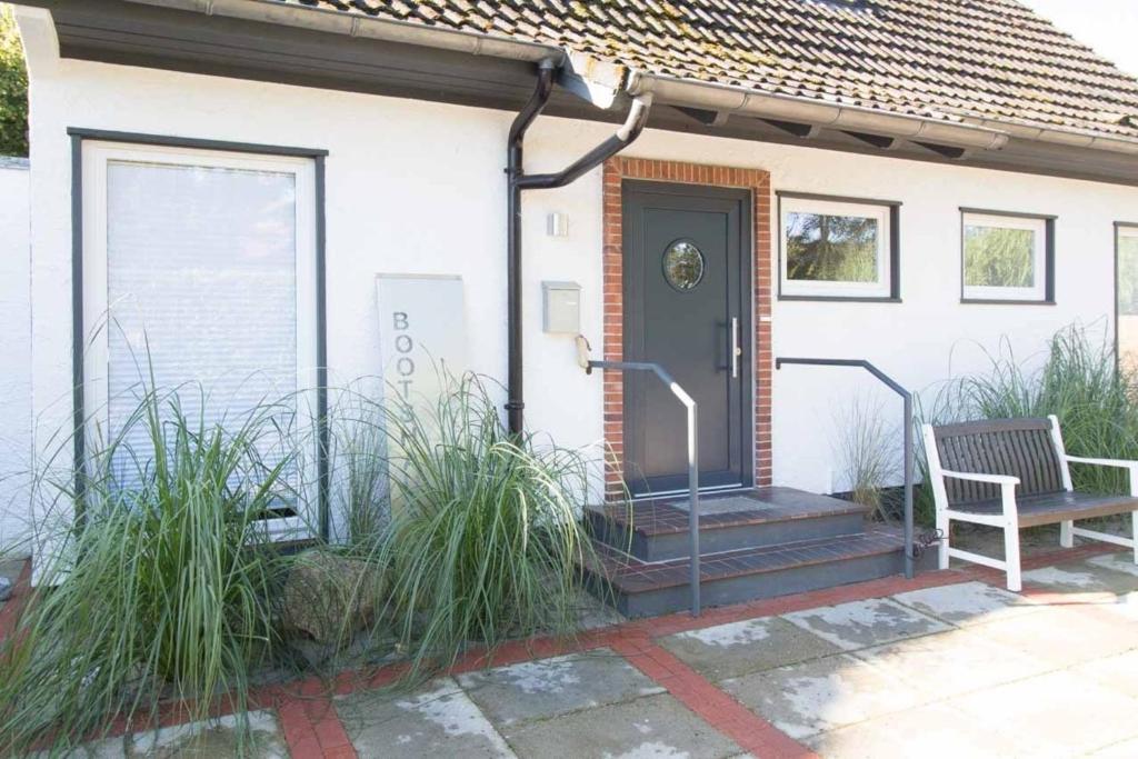 a front door of a house with a bench at Bootshaus in Timmendorfer Strand