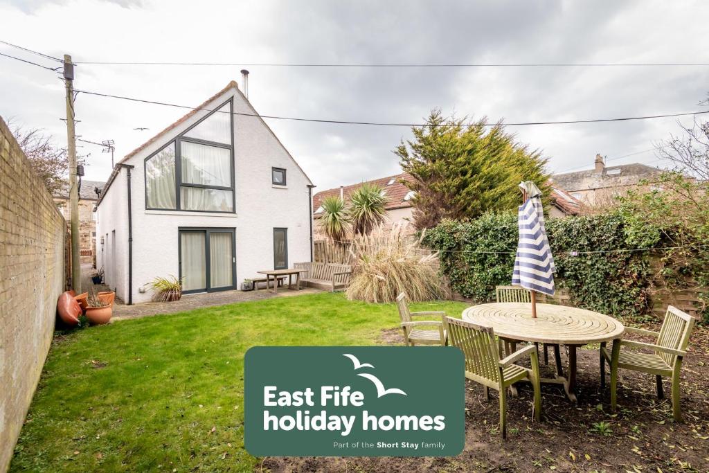 a house with a sign that says east fire holiday homes at Juniper Cottage - Elie in Elie