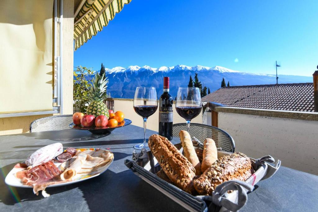 a table with two glasses of wine and a plate of food at La Portella - Gardagate in Tignale