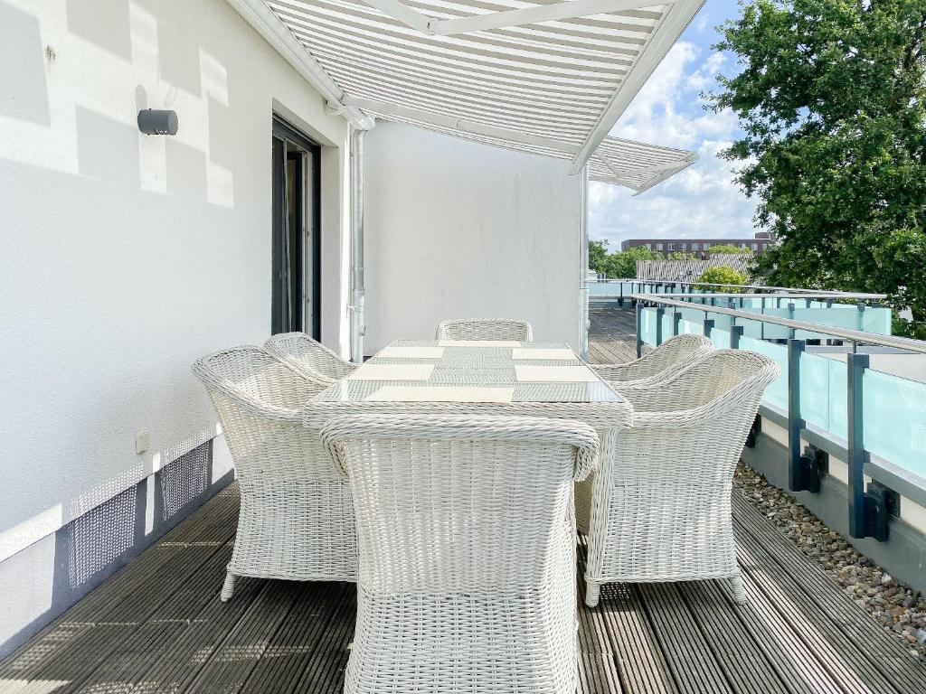 a table and chairs on the balcony of a house at Loft in Timmendorfer Strand