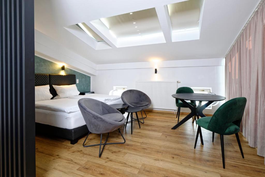 a bedroom with a bed and a table and chairs at Boardinghouse Rosenheim in Rosenheim