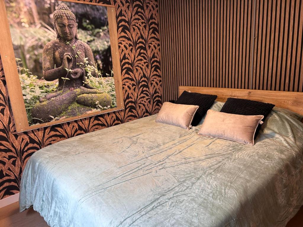 a bedroom with a bed with a picture of a statue at Vinkenland in Koningslust