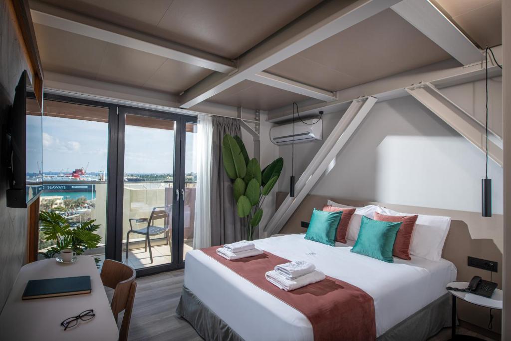 a bedroom with a large bed and a large window at Infinity City Boutique Hotel in Heraklio