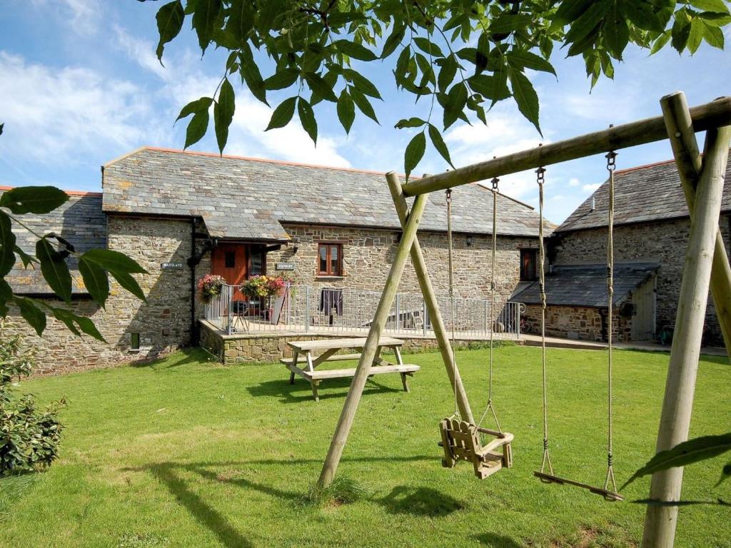 a swing in front of a stone house at 4 Bed in Bude oc-corys in Morwenstow