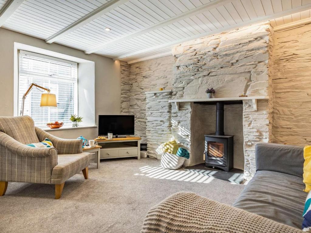 a living room with a stone wall and a fireplace at 1 Bed in Wadebridge oc-87740 in Wadebridge