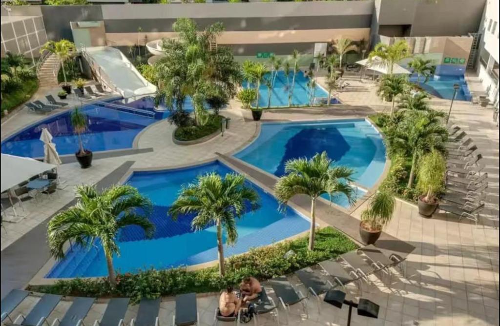 an overhead view of a pool with palm trees at Flat veredas 300 metros HOT PARK com ar na sala in Rio Quente