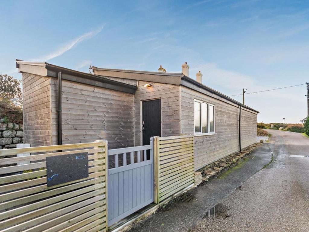 a small house with a fence next to a road at 1 Bed in Penzance oc-93410 in Sennen