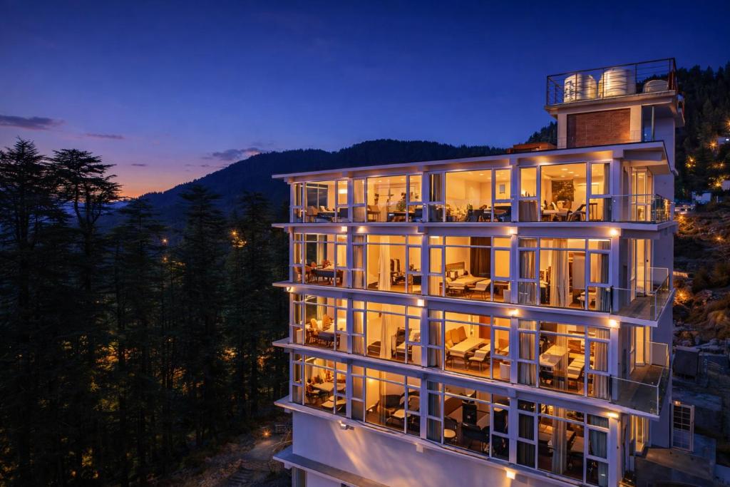 a large building with a lot of windows at night at White Castle Himalayan View by Lavender Hotels in Shimla