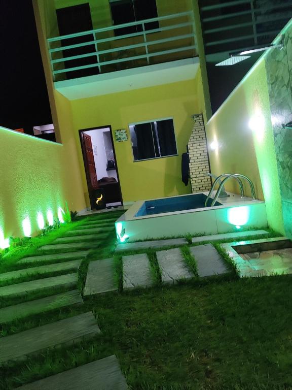 a house with a bathtub in the yard at night at Terramar condominium! Coral beach! in Tamoios